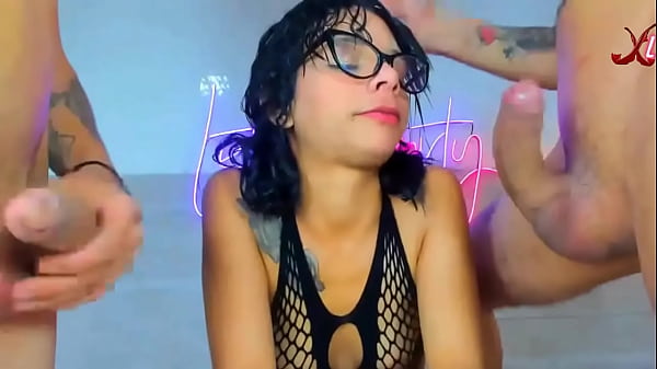 Girl With Glasses On Her Knees Takes Two Huge Cocks Deep Down Her Throat